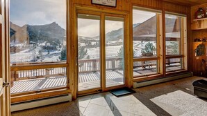 A room with large windows offering a view of a snowy mountain landscape.