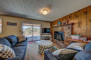 A cozy living room with a fireplace, a television, and a stone accent wall.