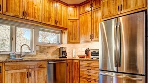 Eine moderne Küche mit Holzausstattung, Edelstahlgeräten und einem großen Fenster.