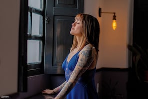 A person standing by a window with a light fixture above it. - La Banksia Hotel (Quito)