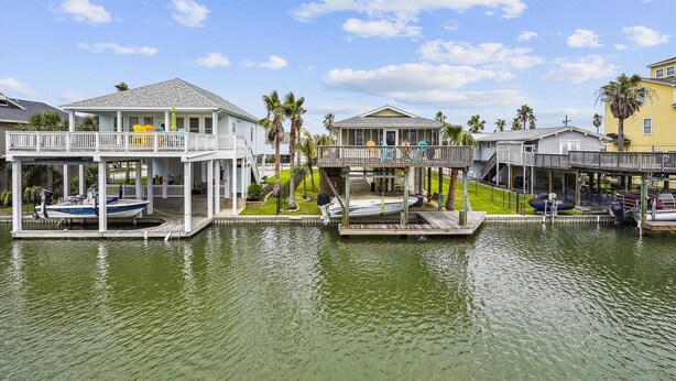 A waterfront property with multiple decks, boats, and a clear view of the water. - All Day Bay Dream by Ryson Vacation Rentals (Galveston)