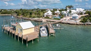 A waterfront property with a dock, a small house, and a boat named Dragon Slayer.