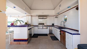 A compact kitchen with white cabinets, a stainless steel stove, and a sink.