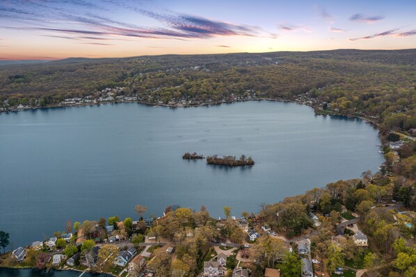 Un lac entouré de quartiers résidentiels, avec des maisons et un quai au centre.