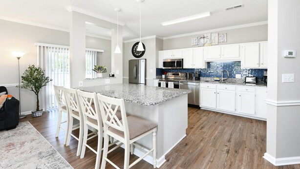 A modern kitchen with white cabinets, a granite countertop, and stainless steel appliances. - Beautiful Villa in Myrtle Beach within 4 min walk to the beach (Myrtle Beach)