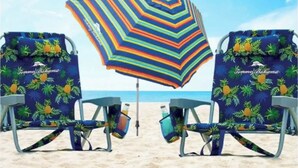 Two beach chairs with a tropical pattern and a colorful striped beach umbrella on a sandy beach. - Beautiful Villa in Myrtle Beach within 4 min walk to the beach (Myrtle Beach)