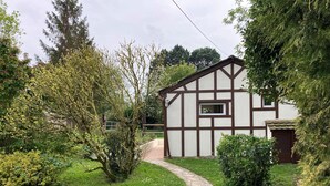 Una casa tradicional con entramado de madera y un camino de piedra que lleva a la entrada.
