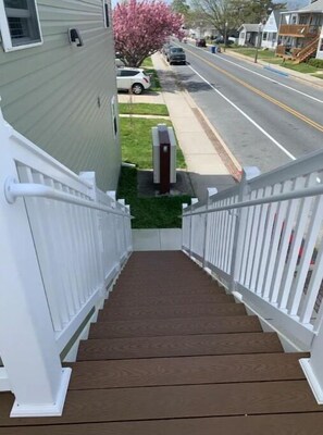 Staircase leads to a welcoming front door, flanked by white railings.