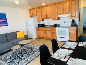 Enjoy cooking in the fully equipped kitchen with a refrigerator, microwave, and oven. Relax in the living area with a sofa and dining area with a table and chairs.