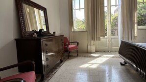 A room with a dresser, a chair, a radiator, and a window with curtains. - Art Nouveau style villa facing Mondello beach (Palermo)