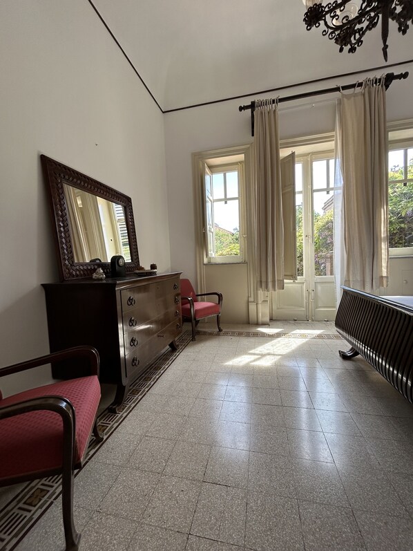 A room with a dresser, a chair, a radiator, and a window with curtains. - Art Nouveau style villa facing Mondello beach (Palermo)