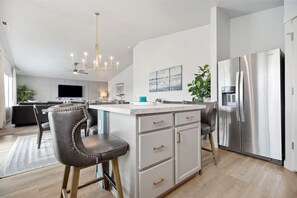 Enjoy cooking in this well-lit kitchen with a spacious island, sink, and comfortable seating area.