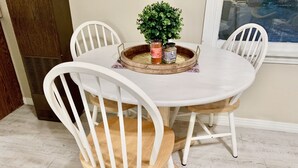 A dining table with white chairs, a small potted plant, and two condiment jars. - Historic District, Downtown, STE 2 (Rapid City)
