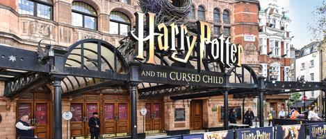 Exterior de un teatro con un cartel que anuncia 'Harry Potter y el niño maldito'.