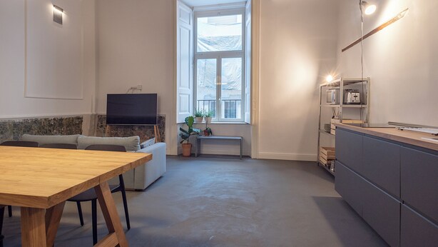 Et moderne køkken med spiseplads, et fjernsyn og et stort vindue.