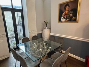 Enjoy meals in this dining area with a glass-top table and six chairs, surrounded by a large window offering a view of the outdoors.