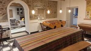A cozy room with a foosball table, a piano, and a checkered floor.