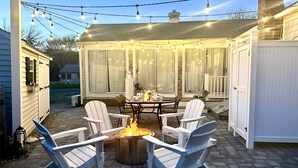 A covered patio with outdoor seating, a fire pit, and string lights. - Outdoor Cape Cod Oasis just 5 minutes to S Village Beach! (Dennis)