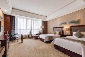 A hotel room with two beds, a desk, a chair, a lamp, and a painting on the wall. - Jurong Yukun MOLTON Hotel (Jurong)
