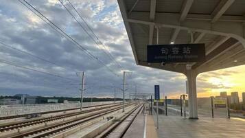 A railway station platform with multiple tracks and a shelter.