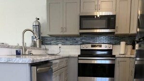 A modern kitchen with stainless steel appliances, a built-in oven, and a microwave. - Aqua Diver is a darling 1 BR house on the East end of Panama City Beach, Florida (Panama City)