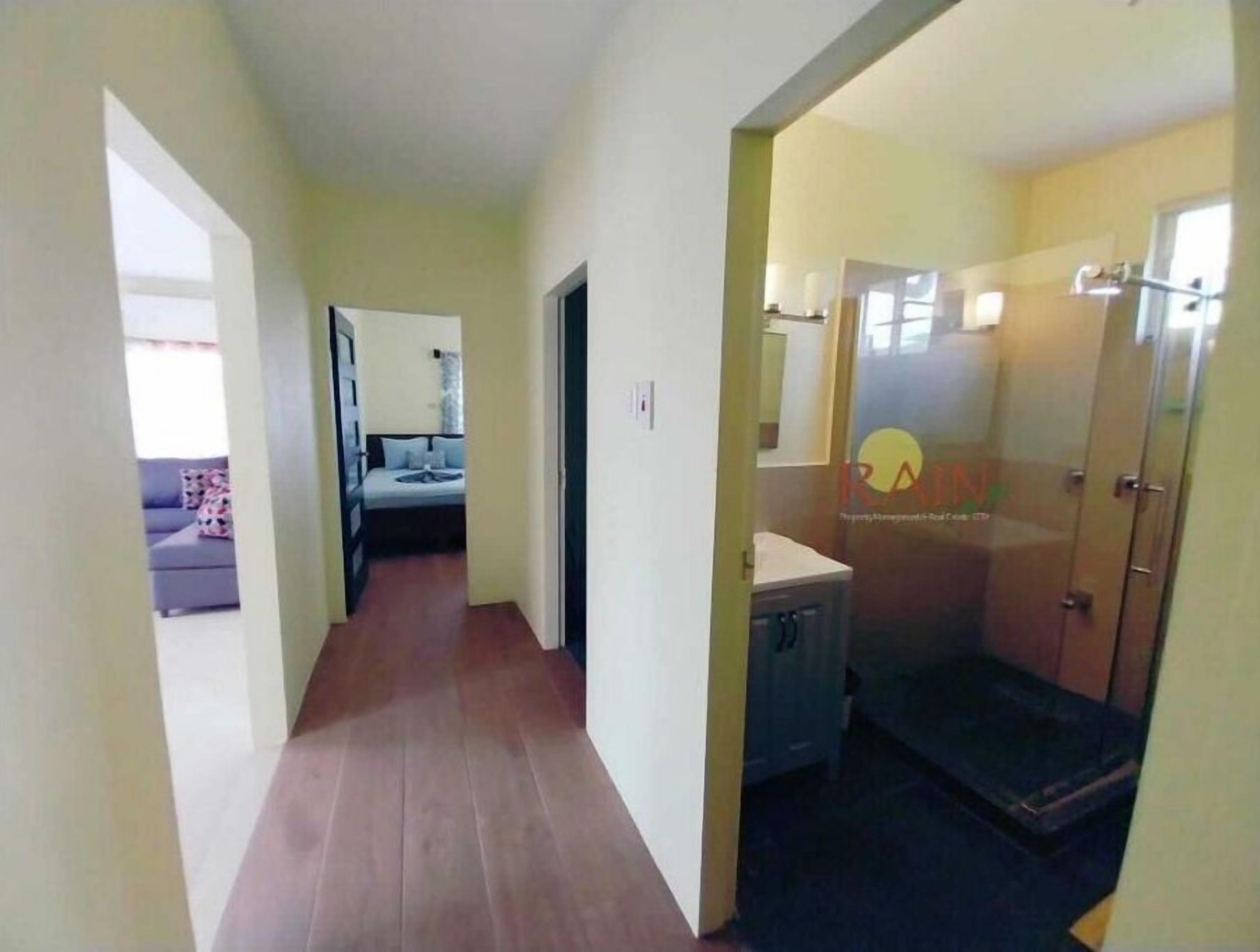 Un pasillo estrecho con una cama y un baño a la derecha.