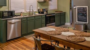 Una cucina compatta con isola centrale, elettrodomestici integrati e un'area pranzo con sedute.