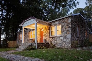 A stone house with a porch and a front door. - a whimsical stay in the mountains (Hendersonville)