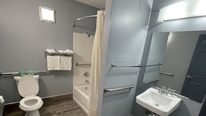 A bathroom with a shower, toilet, and sink. - Jackson motel  (Murfreesboro)