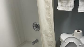 Ein Badezimmer mit Badewanne, Toilette und Duschvorhang.