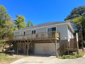 Two-story home with a covered porch and garage door, featuring a staircase to the upper level.