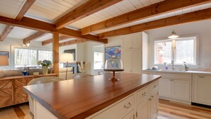 A kitchen with wooden beams, white cabinets, and a wooden countertop. - Private Hot Tub & Deck: North Conway Retreat (North Conway)