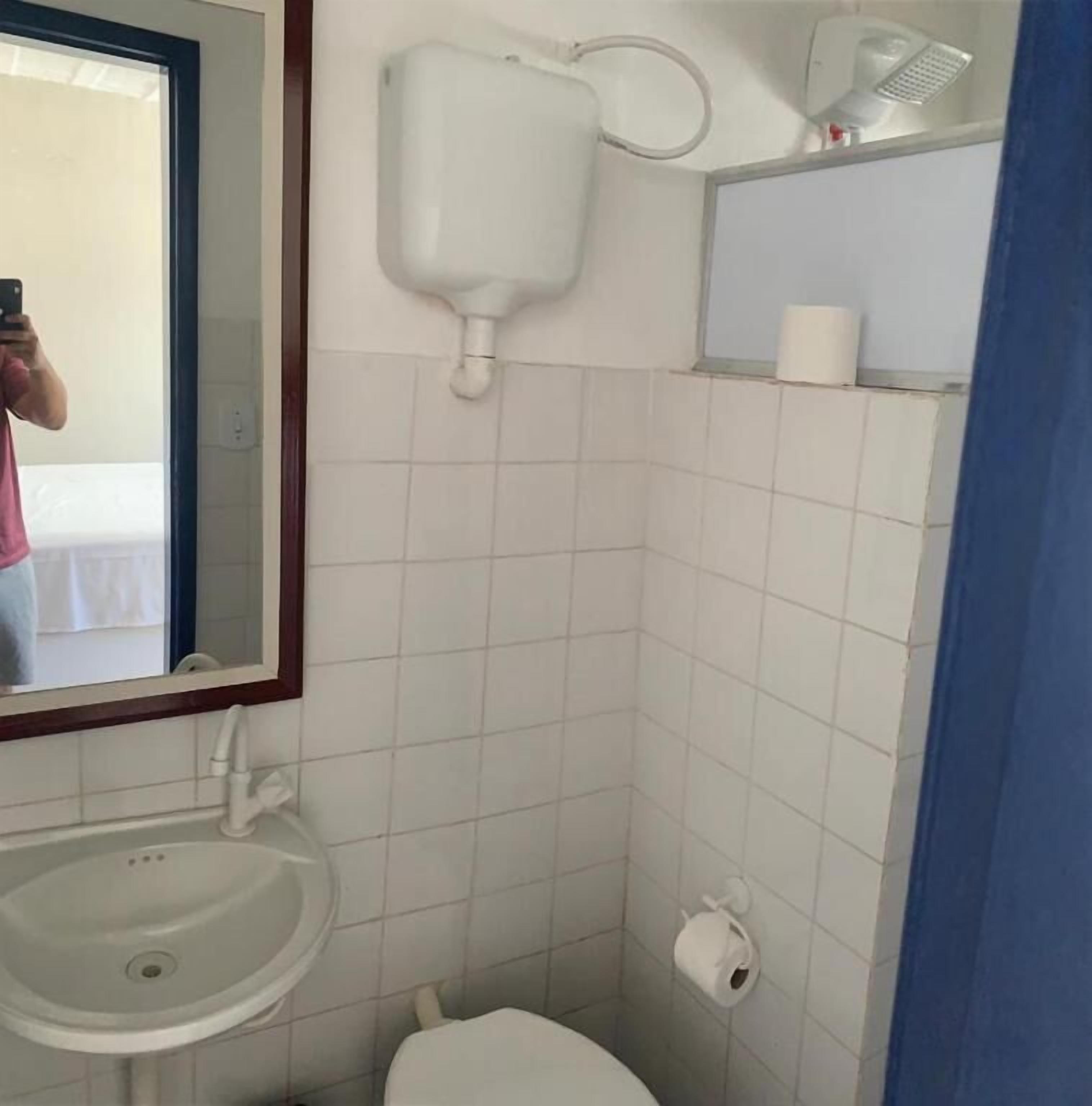 A bathroom with a sink, toilet, and a mirror.