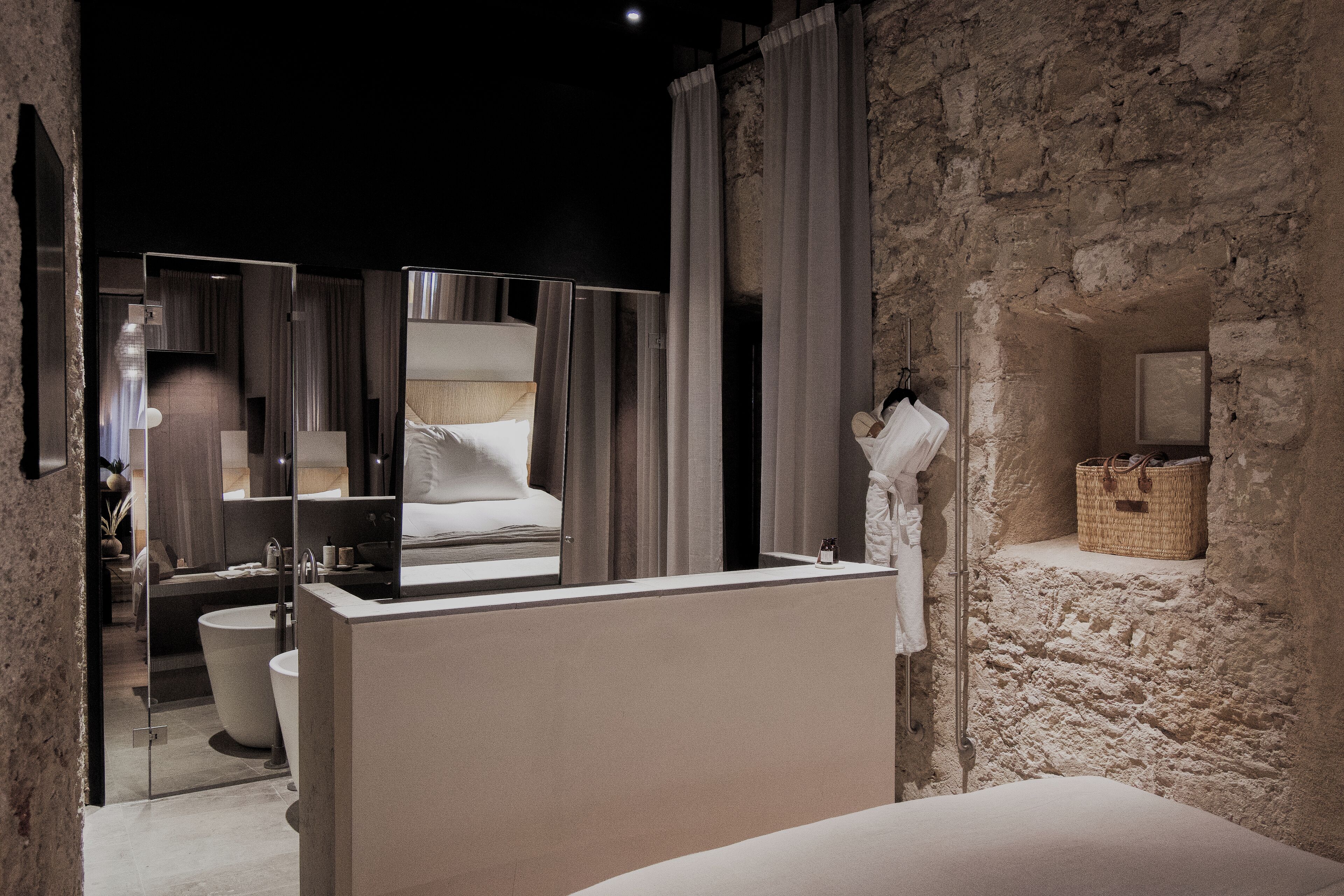 A modern bathroom with a large mirror, a bathtub, and a shower.