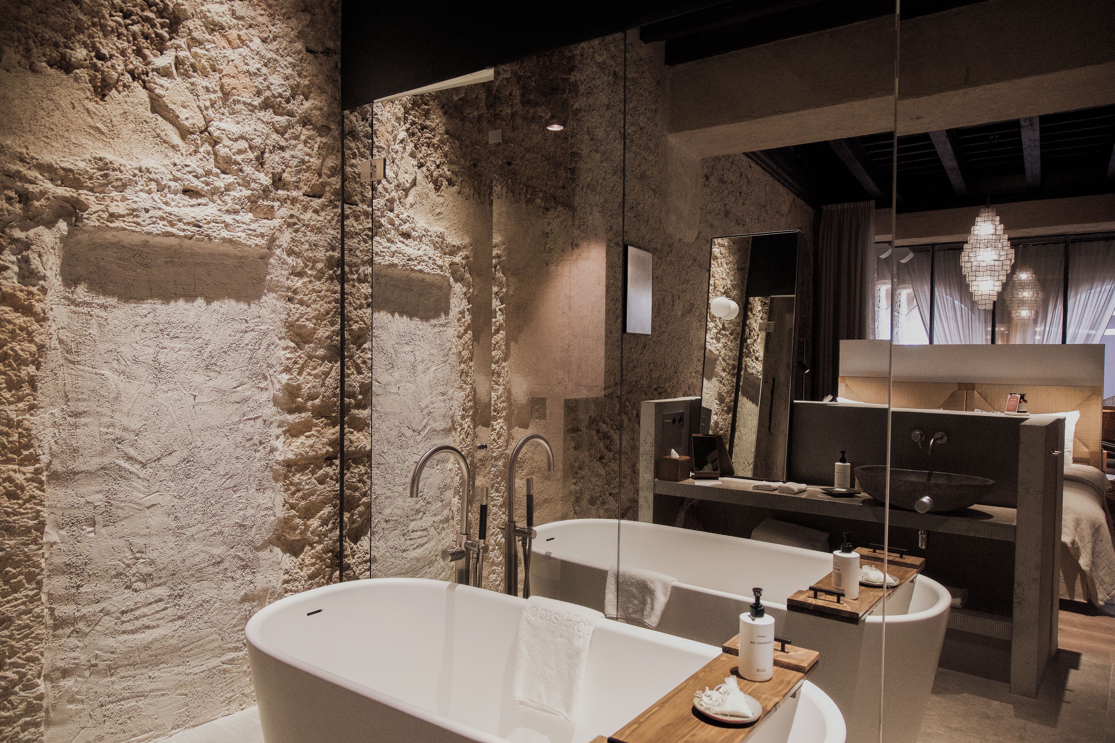 Un baño moderno con una bañera grande, un tocador de madera y un espejo.