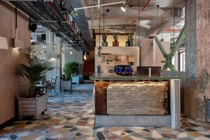 Un interior moderno con una isla central, cañerías expuestas en el techo y un suelo estampado.