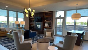A modern living room with a fireplace, comfortable seating, and large windows offering a view. - Comfort Inn & Suites Mountain Grove US-60 (Mountain Grove)