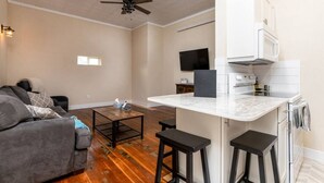 A living room with a gray sofa, a coffee table, and a ceiling fan. - Downtown Spearfish Loft West (Spearfish)