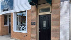 A storefront with a large window and a black door, featuring a sign that reads '2BG'. - Downtown Spearfish Loft West (Spearfish)