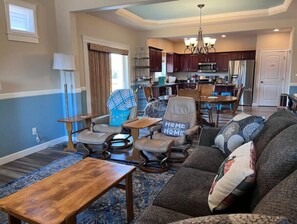 Relax in this stylish living space with a large sofa, dining area, and fully equipped kitchen.