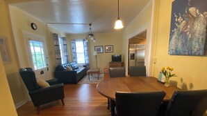 Un salon spacieux avec une table à manger en bois, un canapé et un téléviseur.