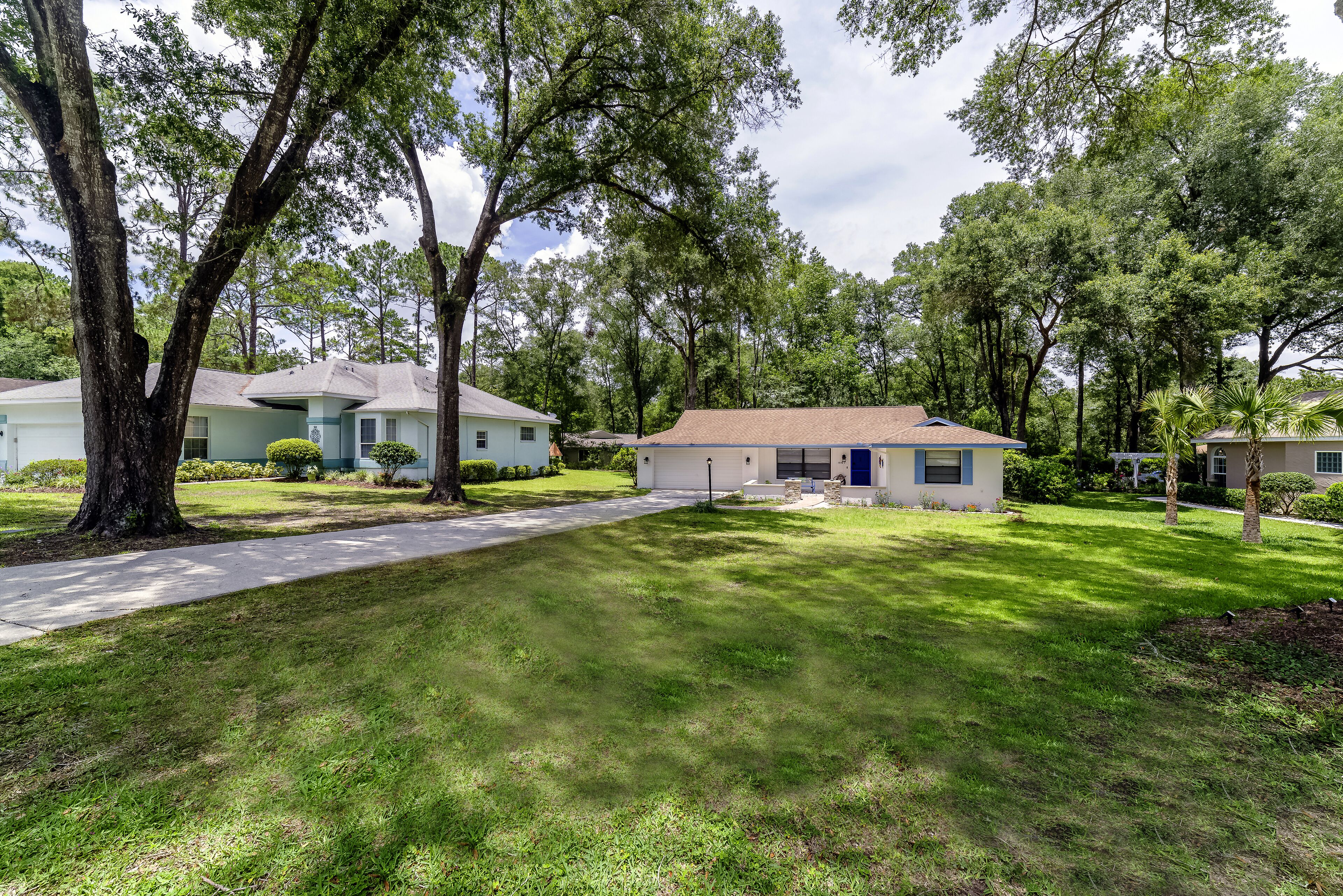 A residential area with houses, a well-maintained lawn, and trees.