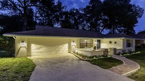 A residential house with a garage, a front porch with a bench, and a landscaped yard. - Haven at Rainbow Springs: Kayaks, Pool, Game Room (Dunnellon)