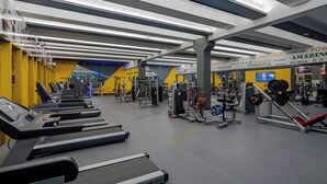 A gym with treadmills, weight machines, and a motivational wall.
