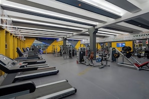 Een sportschool met loopbanden, krachtapparaten en een motiverende muur.