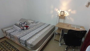 A small, neatly arranged bedroom with a bed, a desk, and a chair. - T4 5 min from the beach (schoelcher)