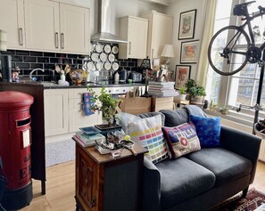 Relax in this inviting living space with a comfortable sofa, modern kitchen, and plenty of storage.