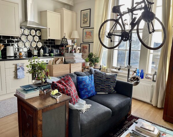 Relax in this stylish living space with a sofa, coffee table, and kitchen area.
