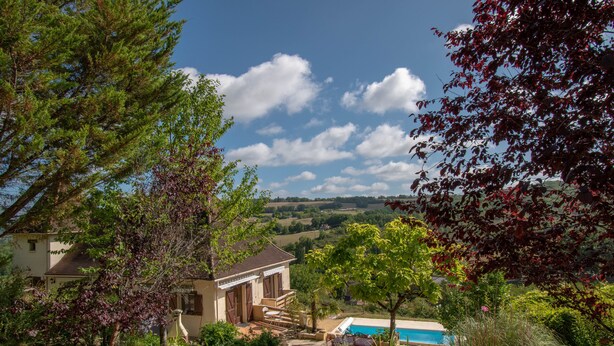 A house with a swimming pool, surrounded by trees and a view of the countryside. - Dordogne gite, amazing views, private heated pool, large gardens, NO ADDED COSTS (Marnac)