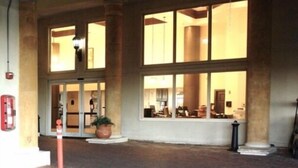 A building entrance with large windows and columns.